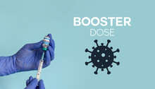 Medical Worker Holding Covid Syringe And Vaccine In Front Of Blue Background With Booster Dose Text