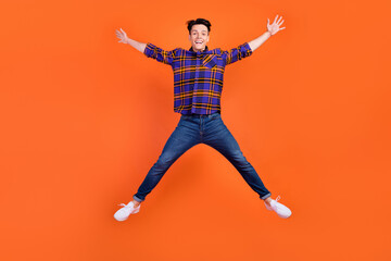 Canvas Print - Full length photo of young funky guy jump wear shirt jeans sneakers isolated on orange background