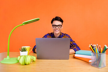 Canvas Print - Photo of millennial optimistic guy type laptop wear checkered shirt spectacles isolated on orange background