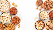 Nuts in bowls. Almonds, hazelnuts, walnuts and other. Healthy food snack mix on white table, top view, copy space