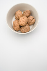 Sticker - Close up of a white bowl with Stack Walnuts isolated on a white