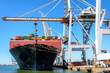 © olrat - A container ship at the dock loaded by a container gantry crane.