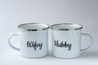 Two white enamel mugs with writings 