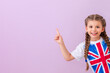 A child in a shirt with a British flag points to your ad on an isolated pink background.