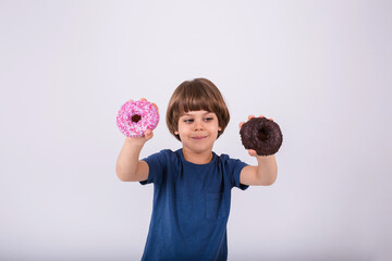 a little boy in a T-shirt holds two donuts on a white background with a place for text