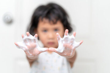 Wall Mural - Small girl washing hands to prevent virus and germs and bacteria in Bathroom 