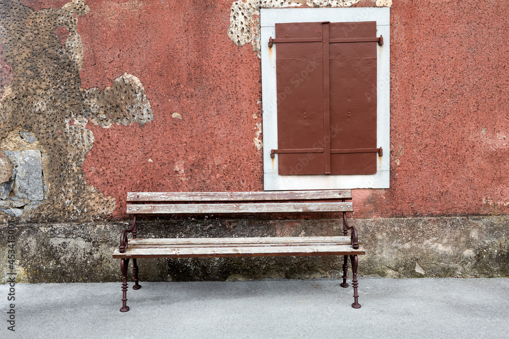 bench in front of a wall with old window in škrbina cars kras slovenia - obrazy, fototapety, plakaty 