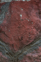 Poster - Vertical shot of a big solid rough stone in red with a rustic texture