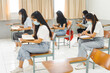 © EduLife Photos - Asian college students back to school with facemask and keep social distance while study in the classroom to prevent COVID-19 pandemic