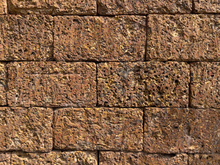 Wall Mural - Laterite brick wall background and texture. Natural Laterite rock for outdoor and tropical garden or Bali garden wall decoration. Selective focus