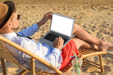 Canvas Print - Man with laptop sitting on sandy beach. Business trip