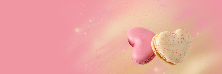 Wall Mural - Two sweet macarons in heart shape  flying isolated on pink yellow background.