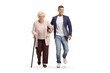 Full length portrait of a young man helping an elderly lady with a walking cane
