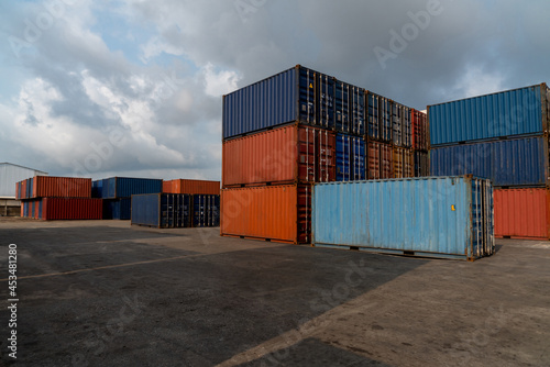 Cargo container for overseas shipping in shipyard with heavy machine . Logistics supply chain management and international goods export concept .