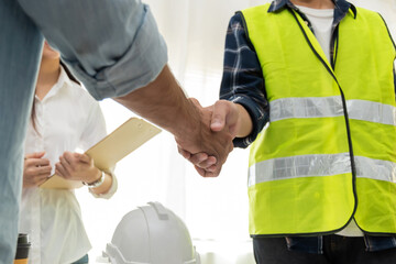Wall Mural - group of architect and engineer construction worker partner handshake in meeting room office at construction site building, industrial, partnership, construction contract and contractor concept