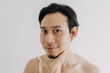 © Sevendeman - Happy Asian man show off his face apply skincare product.