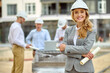 © zinkevych - Joyous determined female construction manager in a hardhat standing outdoors