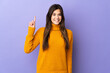 © luismolinero - Teenager Brazilian girl over isolated purple background pointing up a great idea