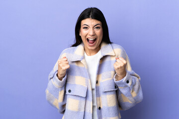 Wall Mural - Young brunette woman over isolated purple background celebrating a victory in winner position