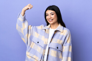 Wall Mural - Young brunette woman over isolated purple background doing strong gesture