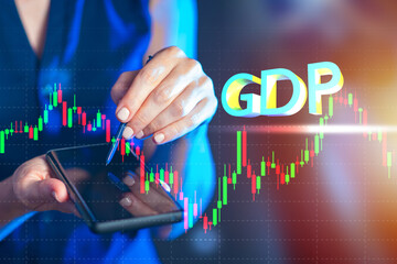 GDP fluctuation graph. Concept - analytics of state GDP. Woman analyst demonstrates graph of smartphone.  word GDP next to woman. Selective focusing. Analysis of economic situation.