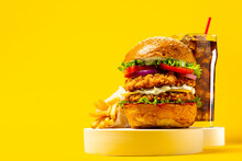 Fresh Big Breaded Chicken Burger With Double Cutlet, Fries And Cola On Yellow Background. Fat Unhealthy Street Food. Copy Space