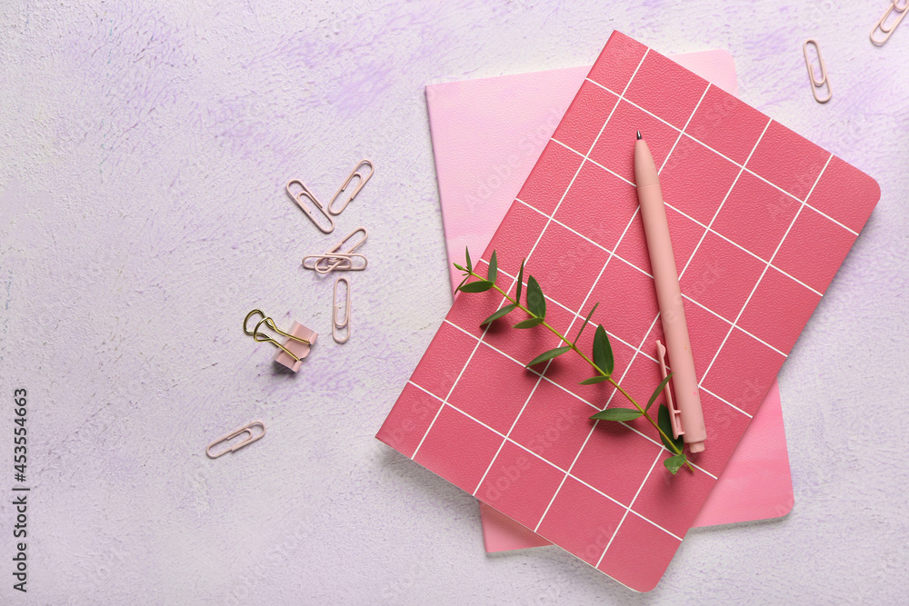Composition with notebooks, pen and clips on color background