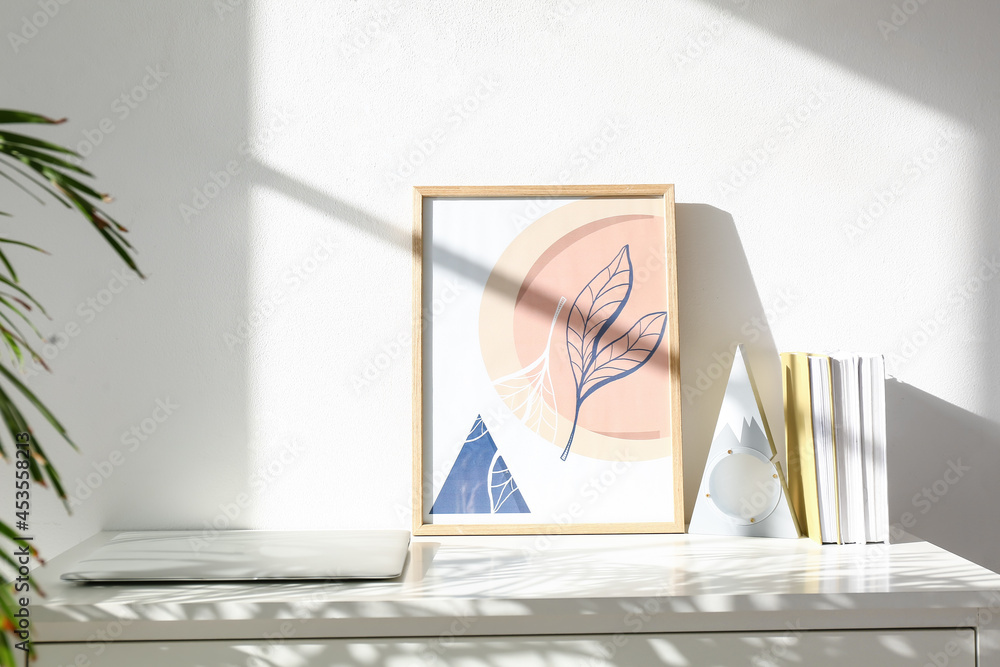 Modern workplace with laptop near light wall