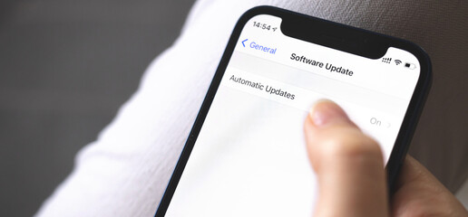 Software update screen on mobile phone close-up, automatic update button, banner photo