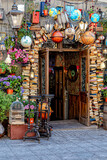 Fototapeta Kuchnia - Entrance to the cafe is decorated with potted flowers and vintage things