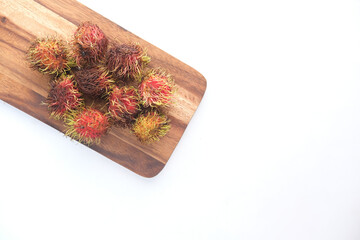 Wall Mural - stack of rambutan in a chopping board on white background 
