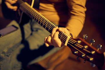 Wall Mural - Male musician playing acoustic guitar on the amplifier in retro vintage room.