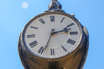 Wall Mural - Metal dial and chairs of a street clock in the park