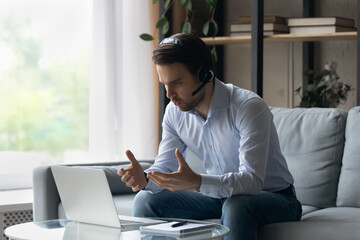 Canvas Print - Focused online teacher giving webinar, virtual training form home. Business man, student, remote employee in headphones, working at laptop, making video conference call, speaking, looking at screen