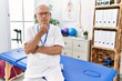 © Krakenimages.com - Senior physiotherapy man working at pain recovery clinic looking confident at the camera with smile with crossed arms and hand raised on chin. thinking positive.