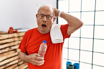 Sticker - Senior man wearing sportswear and towel at the gym crazy and scared with hands on head, afraid and surprised of shock with open mouth