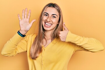 Poster - Beautiful hispanic woman wearing casual yellow sweater showing and pointing up with fingers number six while smiling confident and happy.