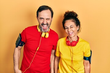 Sticker - Middle age couple of hispanic woman and man wearing sportswear and arm band winking looking at the camera with sexy expression, cheerful and happy face.