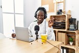 Fototapeta  - Young african woman working at radio studio smiling happy pointing with hand and finger to the side