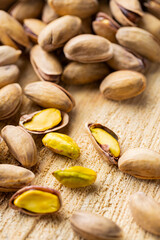 Roasted pistachios nuts. Fried and salty pistachios on wooden background. Close-up