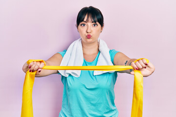 Poster - Young hispanic woman wearing sportswear and arm band puffing cheeks with funny face. mouth inflated with air, catching air.