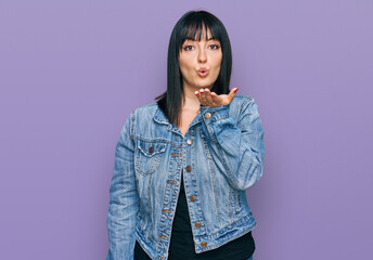 Poster - Young hispanic woman wearing casual clothes looking at the camera blowing a kiss with hand on air being lovely and sexy. love expression.