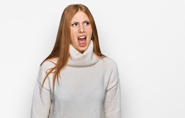 Wall Mural - Young irish woman wearing casual winter sweater angry and mad screaming frustrated and furious, shouting with anger. rage and aggressive concept.