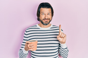 Poster - Middle age caucasian man drinking a cup of coffee smiling with an idea or question pointing finger with happy face, number one