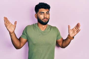 Poster - Arab man with beard wearing casual green t shirt clueless and confused with open arms, no idea and doubtful face.