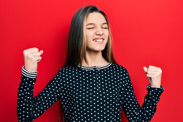 Sticker - Young brunette girl wearing casual sweater very happy and excited doing winner gesture with arms raised, smiling and screaming for success. celebration concept.