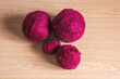 Ovillos de lana granate de diferentes tamaños sobre un fondo de madera. Crochet, ganchillo. Bolas de hilo. Madejas.