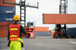 © tool51 - Engineer  use walkie-talkie in order to control container from Cargo freight for import and export.
