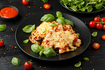 Baked Cauliflower steak with marinara sauce and cheese on plate. Healthy vegetarian food