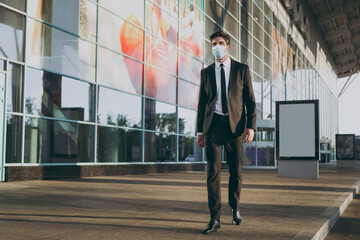 Wall Mural - Bottom view full body young traveler businessman man in black dinner suit sterile mask standing outside at international airport terminal look aside. People air flight business trip lifestyle concept.